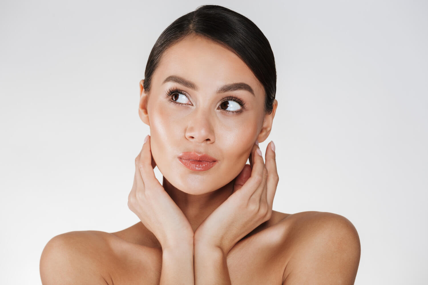 Mulher com rosto definido e mãos no queixo em tratamento de harmonização facial na Smile Center, José Bonifácio, Zona Leste SP.