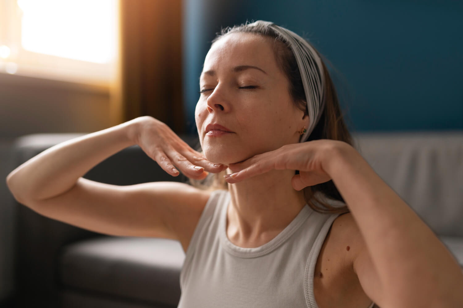 Mulher loira fazendo massagem no queixo, ilustrando o resultado do preenchimento com ácido hialurônico na Smile Center, José Bonifácio, Zona Leste SP.